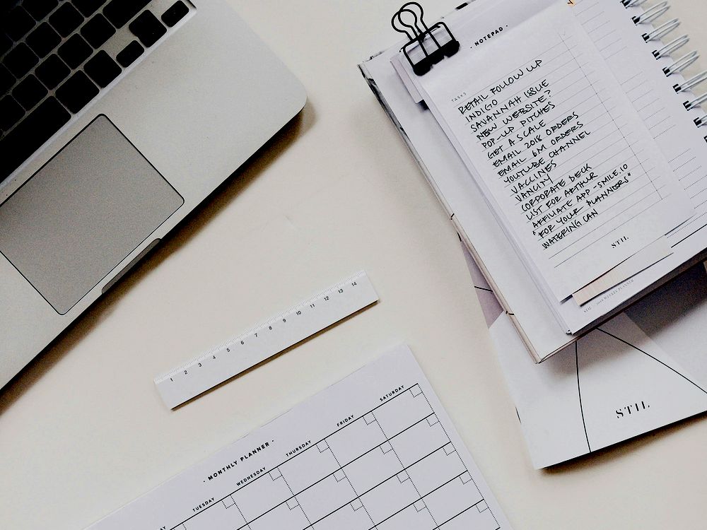Desk with laptop, handwritten task list and monthly planner